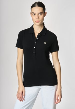Polo shirt nera in cotone, con una patta con bottoni, maniche corte e un piccolo logo ricamato sul petto.