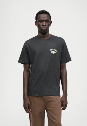T-shirt en coton noir avec un petit logo Rip Curl blanc et vert sur la poitrine gauche. Manches courtes et design classique à col rond.