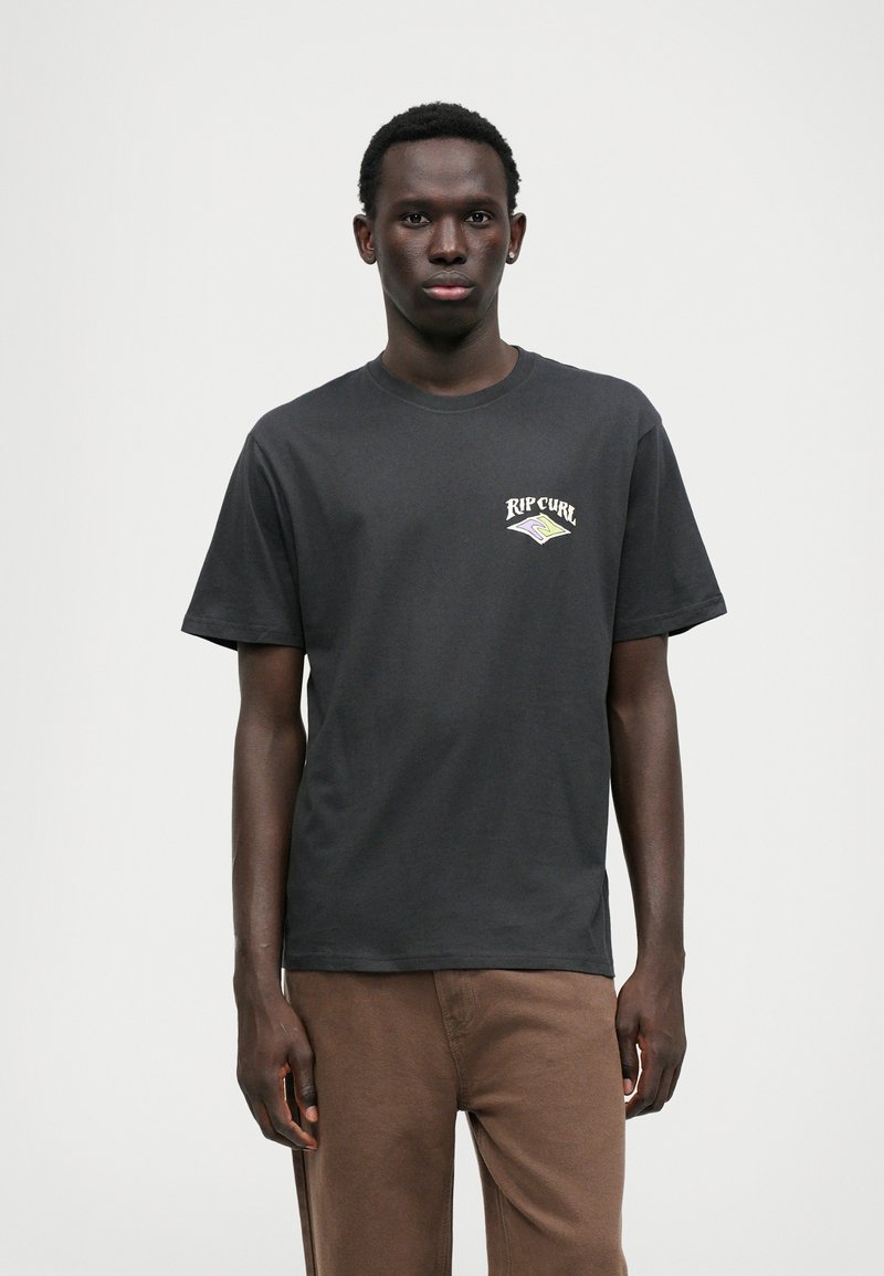 Melna kokvilnas T-kreklā ir neliels balts un zaļš Rip Curl logo kreisajā krūtī. Ar īsām piedurknēm un klasisku apaļu kakla dizainu.