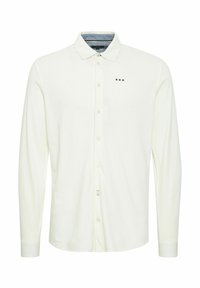 Cămașă polo albă cu mânecă lungă, guler cu nasturi, accente subtile cu logo în roșu, alb și albastru, și guler interior cu model de denim.
