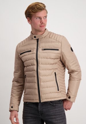 Beige padded jacket with a stand collar, black zippers, and two chest pockets. Ribbed design on shoulders and smooth texture.