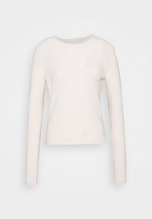 Camicia a maniche lunghe di un rosa chiaro realizzata in tessuto morbido. Presenta un collo arrotondato e un orlo corto con cuciture minime e una texture liscia.