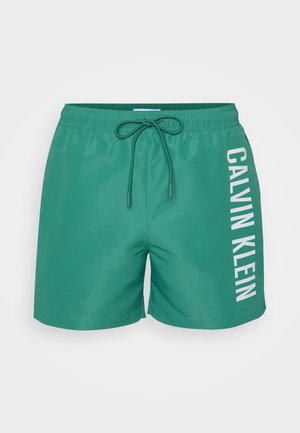 Zielone kąpielówki wykonane z gładkiego materiału, z białym logo "CALVIN KLEIN" po boku oraz regulowanym ściągaczem w pasie.
