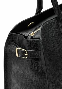 Zwarte leren handtas met een gewelfde textuur, gouden rits en hardware-accenten, met een gesp-detail en stevige handvatten.