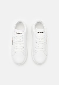 Hvite lær-sneakers med glatt tekstur, minimalistisk design, snøring og "Valentino"-merke på tungen.