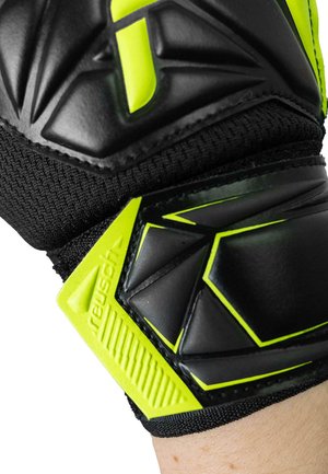 Black and neon green padded glove on wrist, featuring textured and stitched protective panels and breathable mesh fabric.