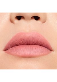 Labial nude mate aplicado en los labios, mostrando una textura suave y un contorno sutil, con un tono rosa suave y líneas de labios definidas.