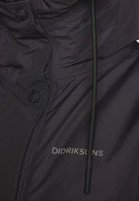 Czarna pikowana kurtka o gładkiej fakturze, z wysokim kołnierzem, guzikami i regulowanym sznurkiem. Wyróżnia si�ę logo "Didriksons".