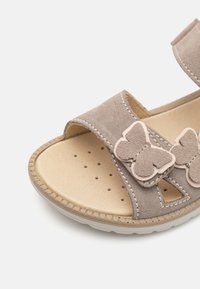 Grå semsket skinnsandaler med borrelås, sommerfuglaccent og perforert beige innersåle. Har en teksturert gummisåle for godt grep.