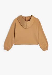 Sudadera recortada en beige, hecha de una tela suave. Cuenta con capucha, hombros caídos y puños de canalé, con un diseño liso y sin acentos visibles.