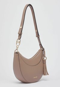 Sac à bandoulière en cuir beige au design incurvé, bordure noire, ferrures dorées et un accent de pampille. Dispose d'une fermeture éclair.