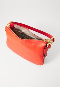 Borsa a tracolla in pelle rossa con una finitura testurizzata, dotata di una cerniera e di una tracolla dorate, e un ampio interno beige con una piccola tasca con cerniera.