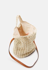 Borsa a rete all'uncinetto di colore crema con rivestimento in tessuto beige e tracolla in pelle marrone chiaro, mostrata aperta su uno sfondo bianco.