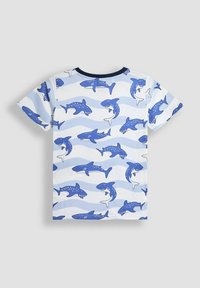 Kurzarm-T-Shirt in Hellblau mit einem Hai-Muster in verschiedenen dunklen Blautönen und Wellen. Aus Baumwolle, mit Rundhalsausschnitt.