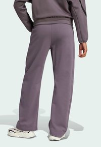 Pantalones de chándal morados hechos de un material suave con un ajuste relajado, que presentan un diseño de pierna recta y bolsillos laterales.
