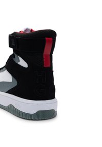 High-top sneaker featuring a black suede upper with a white leather toe, a red accent at the heel, and embossed branding on the side.
