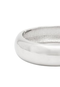 Silverfärgad metallarmband med en slät, polerad yta och en lätt kurva; inuti finns ett strukturerat mönster.