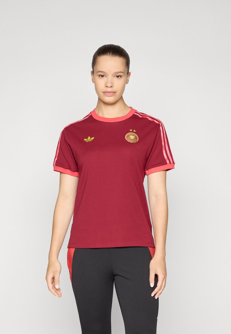 Maillot court à manches courtes bordeaux avec des accents roses, doté d'un col rond, de trois bandes blanches sur les épaules et d'un logo sur la poitrine.
