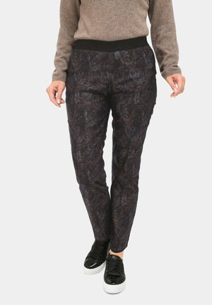 Zwarte broek met patroon en een elastische tailleband, met een donker bloemenontwerp en een slim fit, gecombineerd met zwarte sneakers.