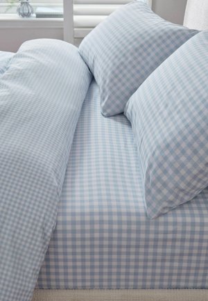 Bett mit hellblau-weiß kariertem Spannbettlaken, passenden Kissenbezügen und Bettbezug in einem hellen Schlafzimmer.