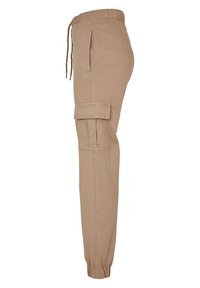 Pantalon cargo beige avec taille élastique, cordon de serrage, poches latérales et poignets froncés. Confectionné en tissu léger, avec un devant plat et une poche cargo.