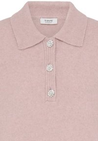 Jasnoróżowa dzianinowa koszulka polo z prążkowanym kołnierzykiem i trzema dżetami na plastrze. Miękka tekstura i klasyczny design.