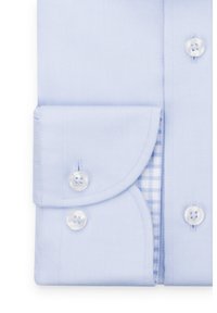 Jasnoniebieska koszula z detalem, charakteryzująca się fakturowanym materiałem, zaokrąglonym kołnierzykiem z zapięciem na guziki oraz kontrastowym wzorem w kratę wewnątrz mankietu.