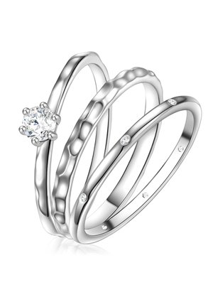 Tri prepletené prstene z lešteného striebra. Jeden má v strede okrúhly diamant; ostatné majú kladivkovú textúru a jemné drahokamové akcenty.