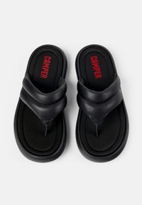 Mustat flip-flopit, joissa on tekokangas yläosa, kaksinkertaiset hihnat ja pehmustettu pohja. 'CAMPER' logo punaisena mustalla pohjassa.