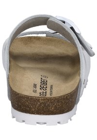 White sandal featuring a cork footbed, grey suede upper, adjustable metal buckle, and textured outsole for grip.