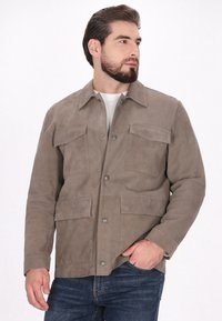 Hellbraune Wildlederjacke mit Knopfverschluss, zwei Brusttaschen und zwei Seitentaschen. Verfügt über einen klassischen Kragen und eine glatte Textur.