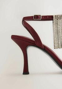 Bordeauxfarbenes High-Heel-Sandale mit Satin-Oberfläche, offener Zehenpartie, Knöchelriemen und silbernen Fransen, ausgestattet mit einer eleganten schwarzen Außensohle.