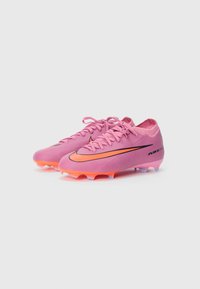 Rosa fotballsko med et strømlinjeformet design, svart Nike-svush og levende oransje farger på sålen og logoen. Polyuretanmateriale.