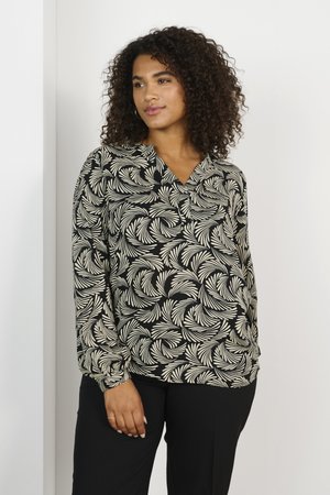 Blouse noire avec un motif de feuilles crèmes, décolleté en V, manches longues et coupe décontractée. Tissu léger avec une texture lisse.