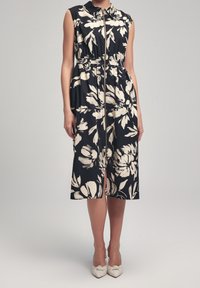 Floral-patterned, sleeveless dress featuring a collared neckline, zip closure, and an elastic waist, in navy with cream flowers.