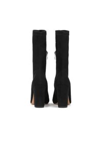 Botas altas de ante negras hasta la rodilla con tacones anchos, que cuentan con cremalleras laterales y una textura suave. El diseño incluye una punta ligeramente afilada.
