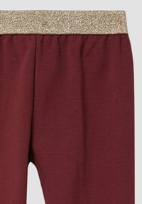 Bordeauxrode katoenen legging met een gouden glinsterende elastische tailleband, een gladde textuur en geplooide details bij de taille voor extra comfort.