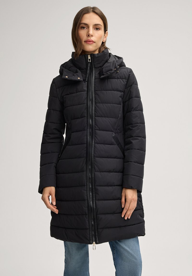 Zwarte gewatteerde jas met ritssluiting aan de voorkant, doorgestikt ontwerp, hoge capuchon en zijzakken. Gladde textuur en middellange lengte.