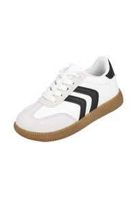 Zapatilla blanca con rayas en forma de chevrón negras, cordones blancos y suela de goma marrón, inclinada a la izquierda sobre un fondo blanco simple.