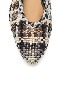 Scarpa in tessuto intrecciato nero, argento e beige con punta affusolata. Presenta un intricato motivo a treccia e una fodera interna liscia.
