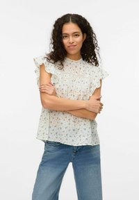 Blouse à imprimé floral en tissu léger, avec un col et des manches froncés ornés de délicates fleurs bleu clair sur fond crème.