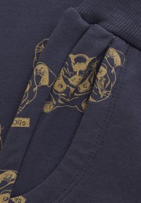 Navy Sweatshirt aus strukturiertem Stoff mit goldfarbenem Hundedruckdesign und geripptem Ausschnitt. Abgerundet mit kleinen Textlabels.