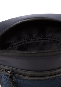 Námořnická textilní taška se zipem na vrchu, s hladkým černým interiérem, zesíleným švem a vnější kapsou na zip pro dodatečné úložné prostory.