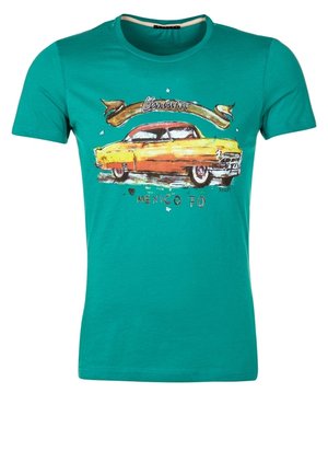 Zielony T-shirt z krótkim rękawem z vintage ilustracją żółtego i pomarańczowego samochodu, tekst "Chicano," oraz "Mexico 70" na przodzie.