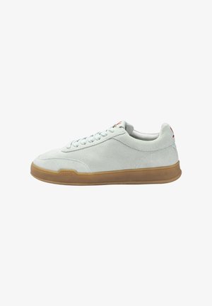 White suede low-top sneaker with tan rubber sole, lace-up design, and subtle embossed branding near the sole's front section.
