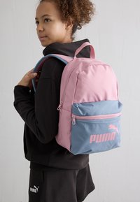 Mochila con un diseño bicolor en rosa y azul, fabricada con un tejido durable, con un bolsillo frontal con cremallera y el logo de Puma en rosa.
