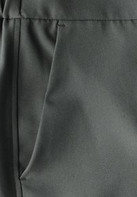 Tissu gris foncé avec une texture lisse, présentant un léger éclat et des coutures visibles le long des bords et des plis. Aucun motif distinct ni matériel.