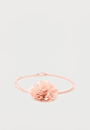 Ροζ ελαστική κορδέλα μαλλιών με απαλό υφασμάτινο λουλούδι με στρωμένα πέταλα στο κέντρο σε λευκό φόντο.