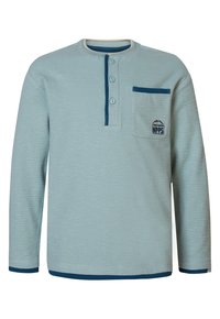 Langärmliges, hellblaues Oberteil mit strukturierter Oberfläche, drei Knöpfen am Hals und einer Brusttasche mit grafischem Logo. Marineblaue Akzente.