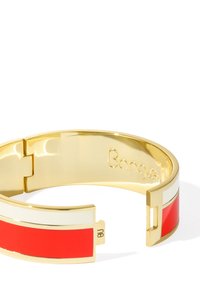 Bracelet en or avec des accents en émail rouge et blanc. Fini lisse et brillant avec un design moderne et ouvert et une fermeture à charnière. Branding notable à l'intérieur.